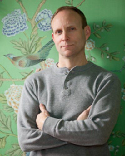 Peter Lalor standing in front of a green hand-painted silk mural